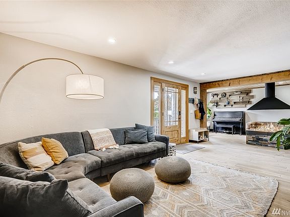 Main Floor Living Room area w/ view of Front Entrance and Cozy Sitting Area w/ Gas Fireplace. 