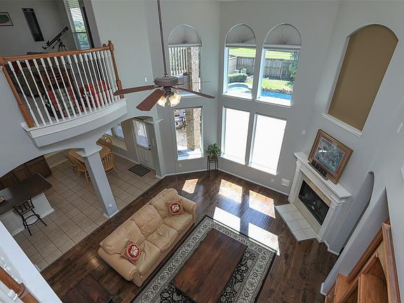 Two story family room with romantic Juliet Balcony, wood flooring, lots of light and a gas log fireplace. Upper windows have motorized shades.