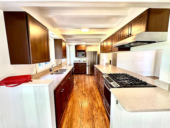 Open galley kitchen with stainless steel appliances