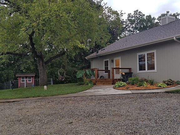 Landscaping on North side of the home, with deck and entry into Laundry room. Chicken coop in the back (Brown & Pink)

