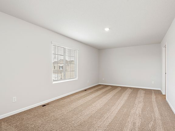 The master bedroom has a large window and lots of space.