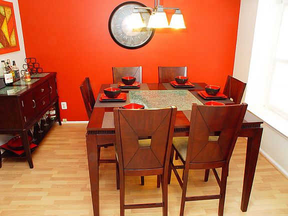 Dining area with Pergo floors, chandelier and double windows for natural light.