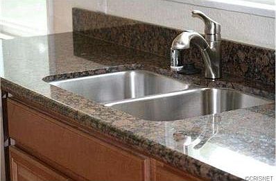 Kitchen also features stainless steel sink as well as granite co