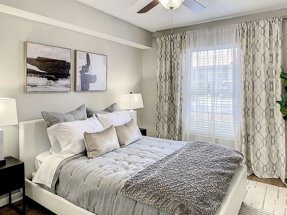 Discover serenity in our spacious bedroom with ceiling fan comfort and expansive sunlit windows.