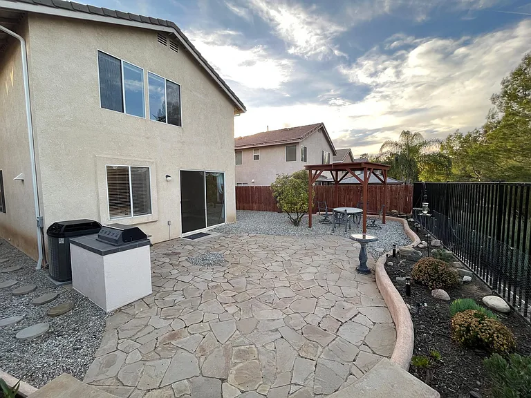 Large, fully landscaped rear yard with pergola, gas BBQ, and stunning views.