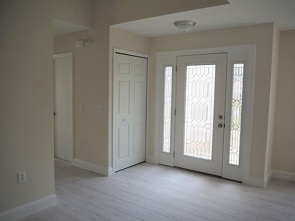 Bright sunny foyer with coat closet. Looking toward short hall that leads to garage, first floor office, formal living room or bedroom and half bath.