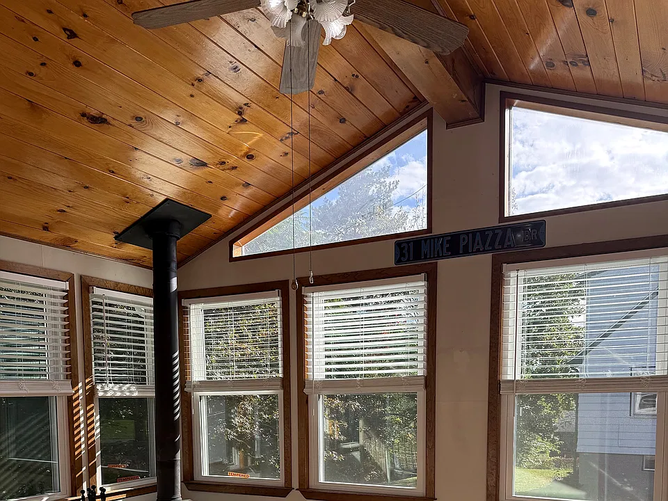 Look up. Knotty pine, an exposed beam, and clerestory windows full of sky.