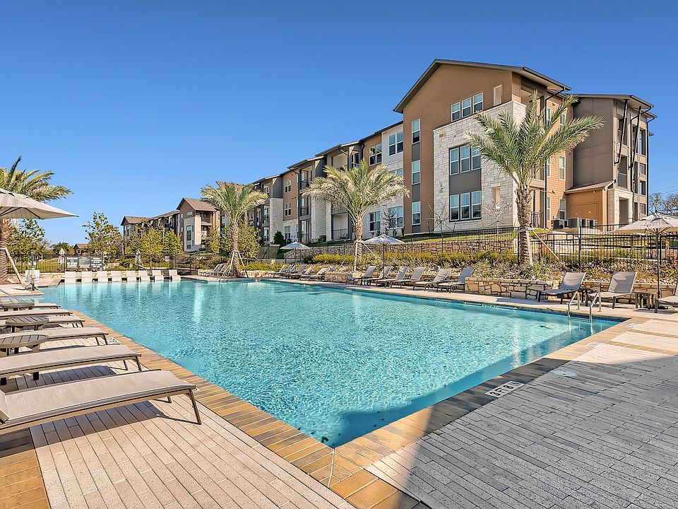 Resort-style swimming pool with lounge chairs and umbrellas