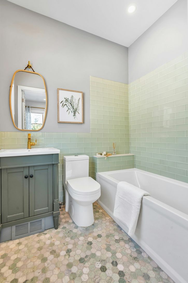  Luxurious light green glass tile and penny porcelain tile floor.