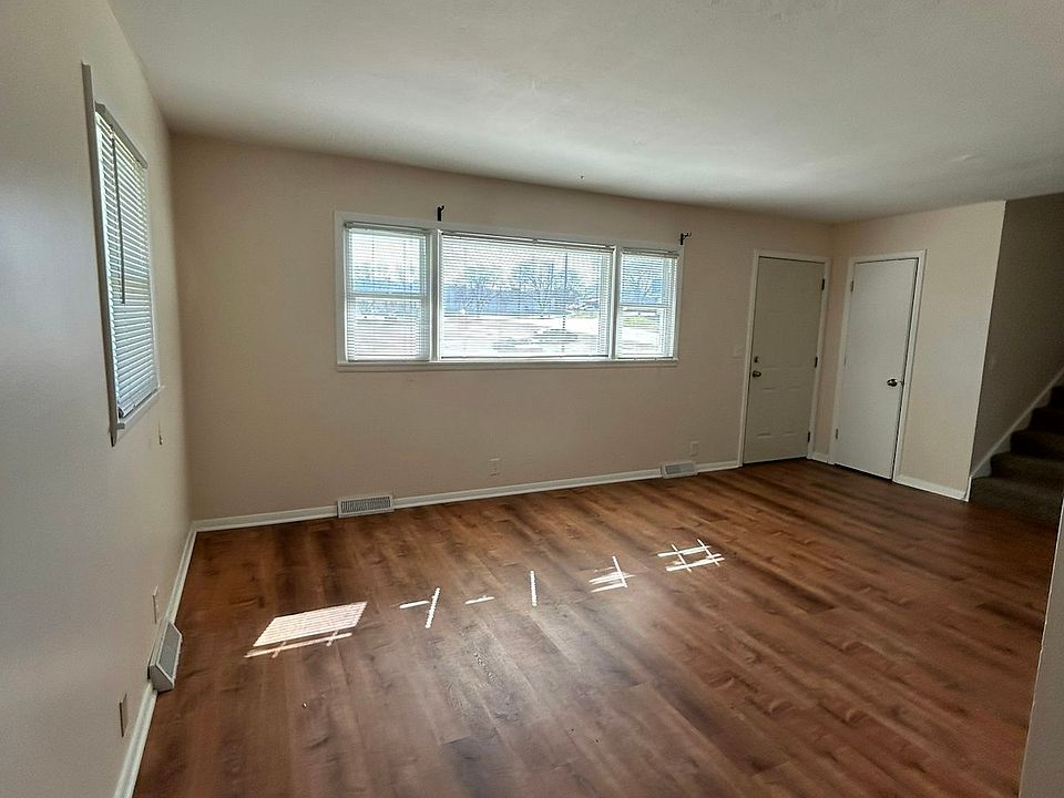 (Living Area wide view) Spacious living area with large windows providing plenty of natural light and durable wood-style flooring throughout.