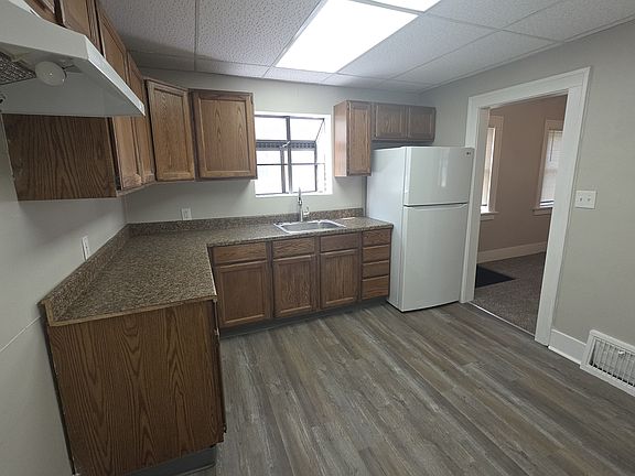 Kitchen has a great cabinet space, a refrigerator and a stove. The window over the sink is a greenhouse window for plants.