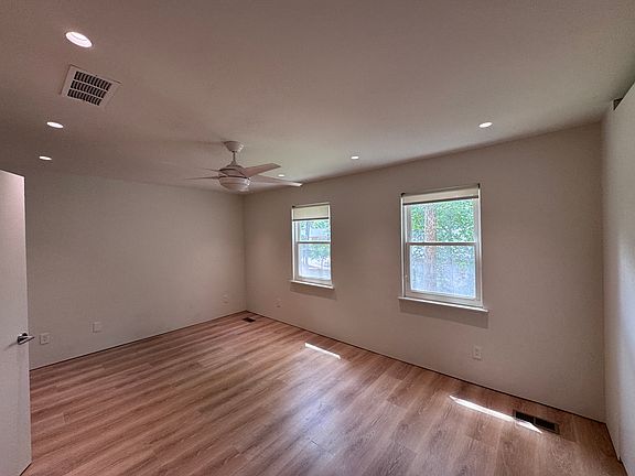 Bedroom 1 - Spacious primary-style bedroom with new flooring, recessed lighting, and natural light.
