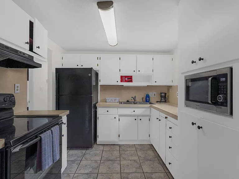 Efficient U-shaped kitchen with ample cabinet storage, laminate counters, and a full appliance set for everyday cooking.