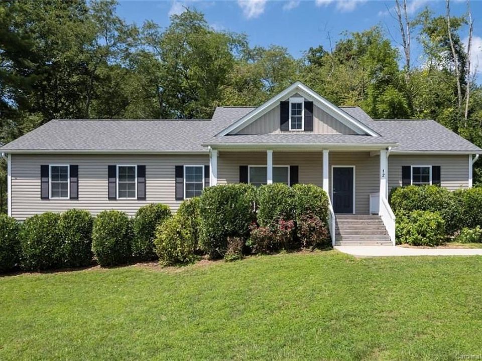 Large front lawn, main home entrance and covered porch