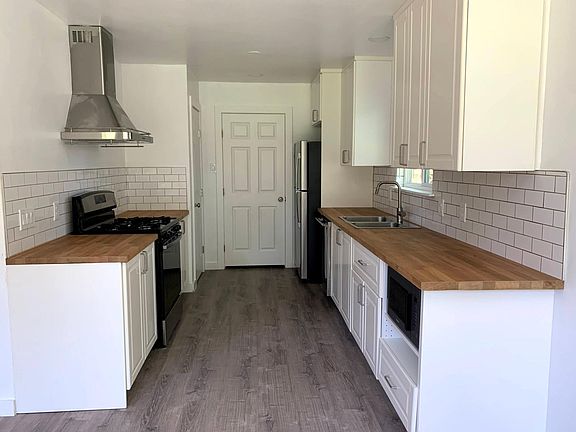 A brand-new kitchen includes a pantry (back left) and opens into the laundry room (back door). All appliances, fixtures, and windows are also new.