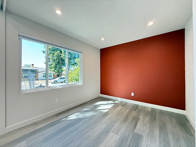 Forward facing living room with blackout shades, recessed lighting and laminate flooring.