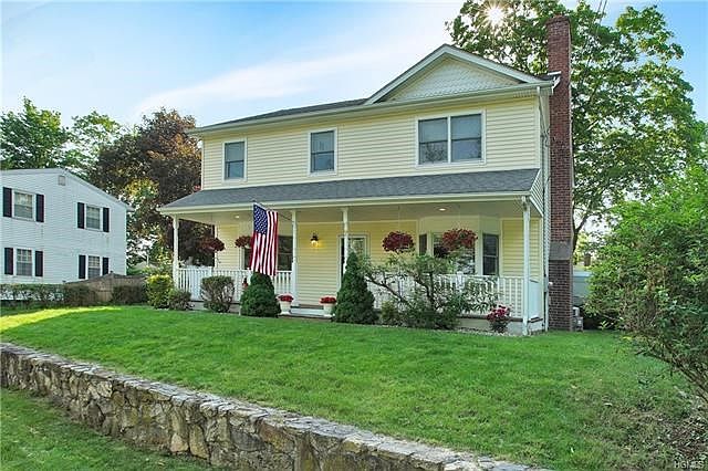Cheerful yellow colonial with gracious front porch.