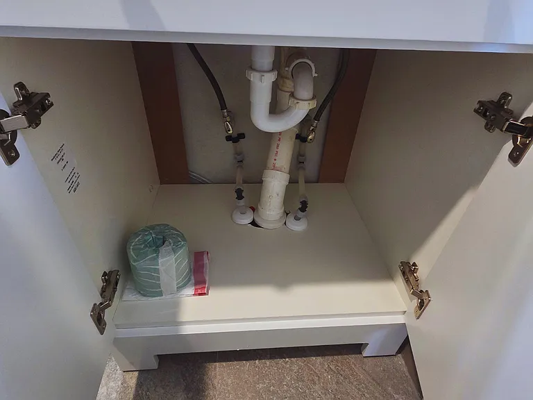 Cabinet includes toilet paper and plastic bags for guest convenience