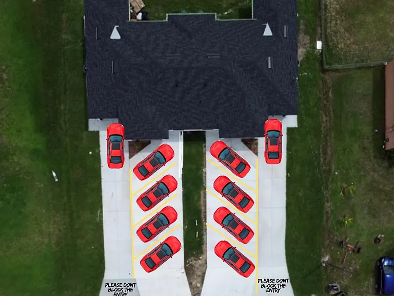 Overhead exterior view highlighting a paved parking area with marked spaces and easy access to the property entrance.