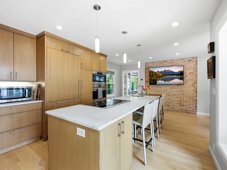 Spacious kitchen with lots of windows and patio entrance as well as adjacent dining room.