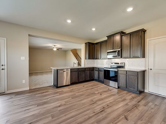 The kitchen features granite countertops and stunning wood cabinetry.