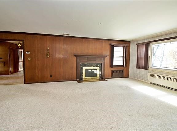 The sun filled, over sized living room features wood burning fireplace.
