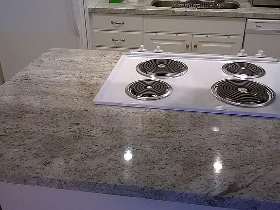 High end granite counter top with slide in stove and over hang for bar stools