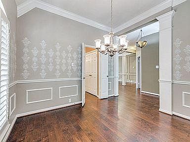 Formal dining room looking towards kitchen door on the left and the living room just past the chandelier.