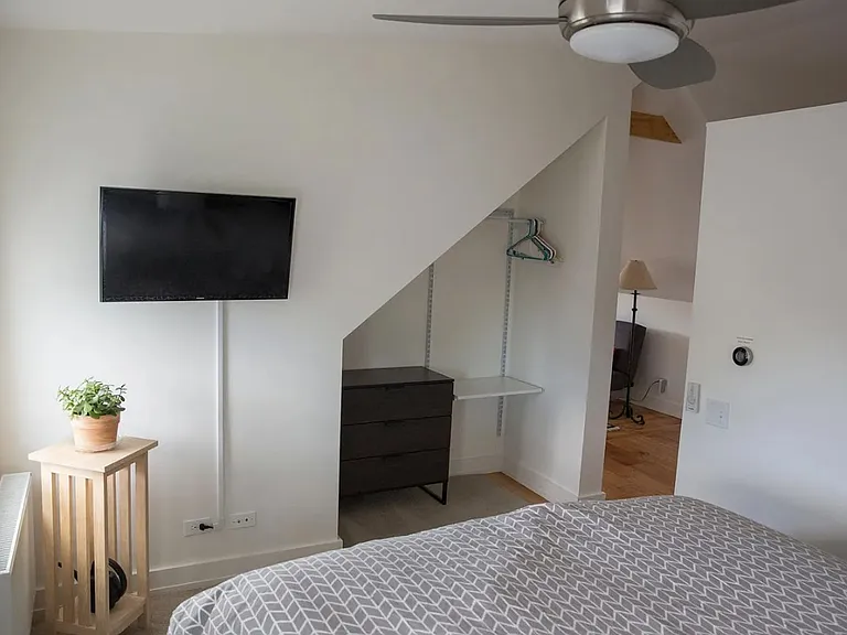 Bedroom with queen bed, tv. ceiling fan.