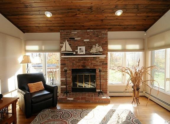 Custom pine ceiling in living room with skylight.  Brick fireplace.