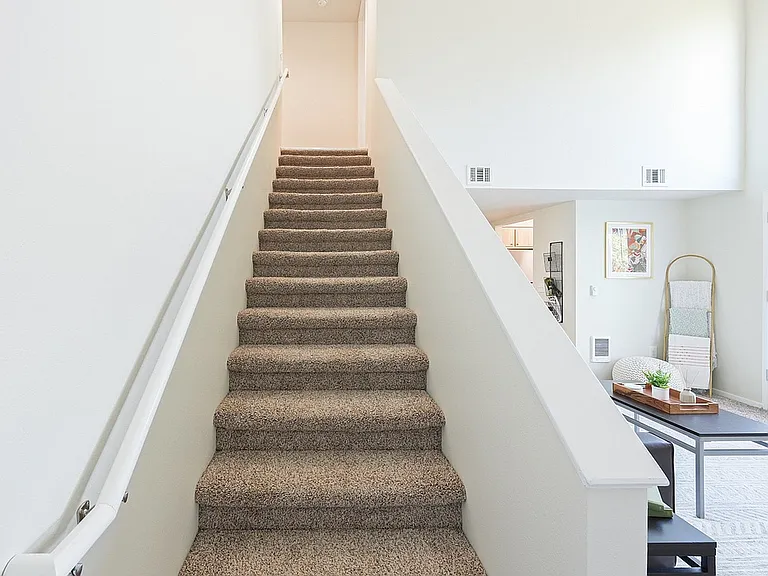 Step into modernity with this stylish staircase and cozy living area.
