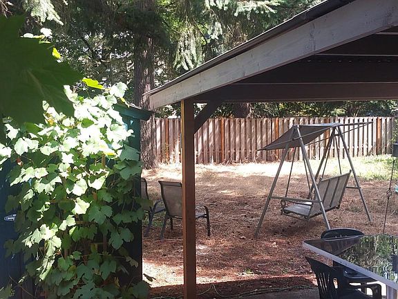 View of back yard and patio looking over side fence.