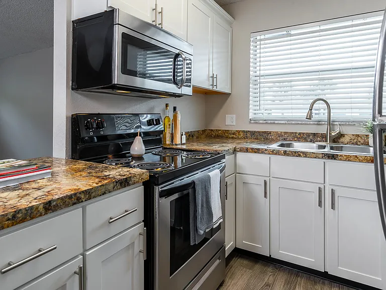 Relish in an open kitchen and sprawling granite-like countertops that transform into a delightful breakfast bar, perfect for prepping and enjoying home cooked meals.