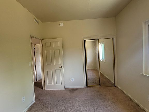 Smaller bedroom with closest facing backyard.