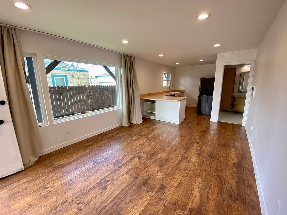 A full length view of large picture windows and into the kitchen. Picture window faces west and gets great light in the afternoon. Kitchen has a standard height bar top and lots of storage. Also has a dishwasher.