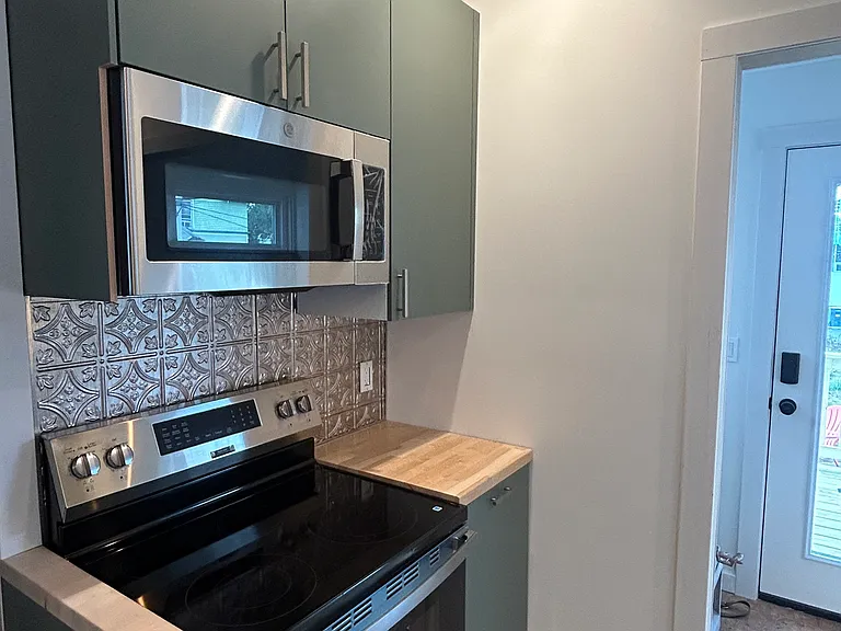 Kitchen stove, new IKEA cabinets, butcher block countertops and cork flooring (still covered by construction RAM board).