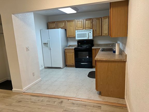 Kitchen with refrigerator, freezer, ice maker, stove, oven, and above stove microwave.