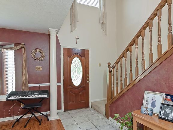 Spacious entry with high ceiling, large dining, and wood laminate floors provide a warm greeting as 