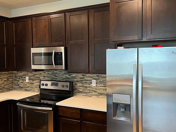 Well appointed kitchen with stone countertops and stainless steel appliacnes