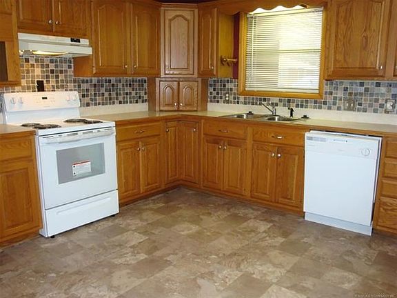New range, dishwasher and flooring in this updated kitchen with tile backsplash.