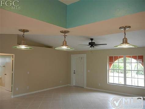 VIEW FROM KITCHEN TO GREAT ROOM WITH ALL TILE ON THE DIAGONAL, FRESH PAINT, AND CONTEMPORY ACCENT LIGHTING.