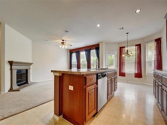 Bright, open kitchen featuring a large center island with sink and dishwasher.