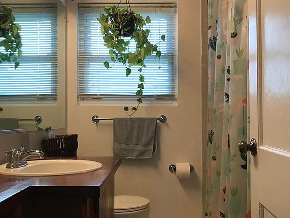 Full bath with window, tub, shower, wood vanity and wood ceiling.