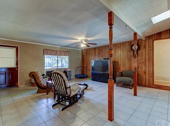 Enclosed patio room with view through window into backyard and hallway to right towards 2 bedrooms