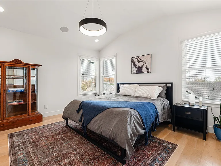 Spacious primary suite filled with natural light and hardwood floors.
