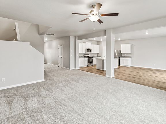 Spacious living room with quick access upstairs and to the kitchen.