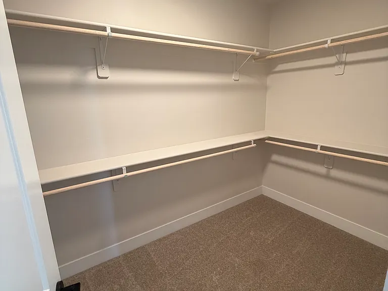 Enjoy spa-like living in the expansive primary bathroom, complete with dual vanities, a large walk-in closet, a separate glass-enclosed shower, and a deep soaking tub.