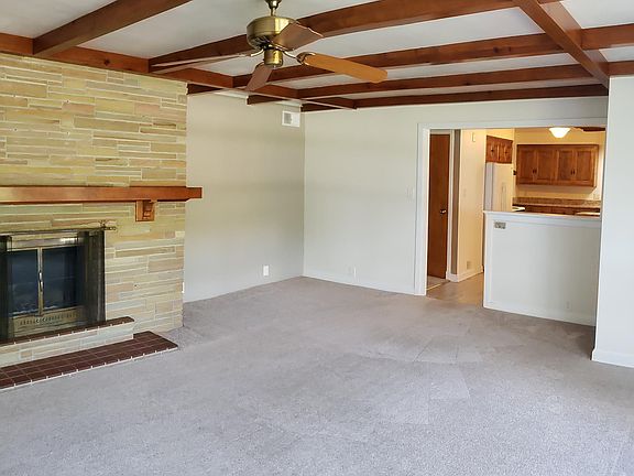 Living Room: Carpeted; wood beams; Fireplace.