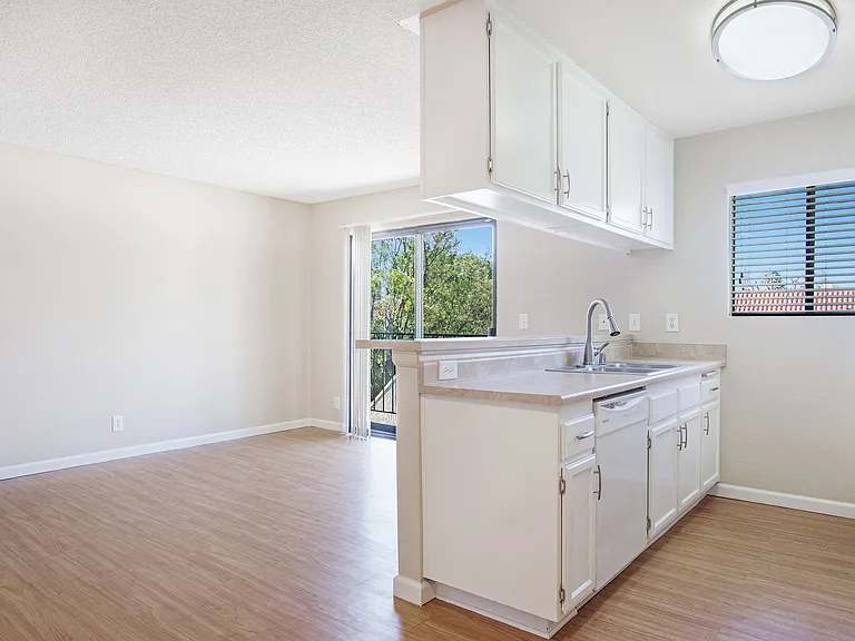 White cabinets and walls in spacious living room with hardwood floors