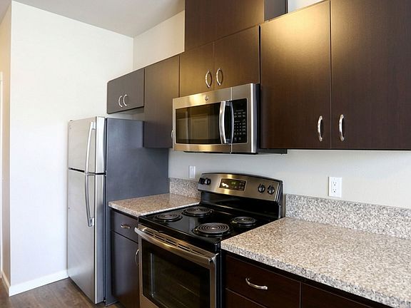 Modern kitchen featuring sleek dark cabinets, stainless steel appliances, and granite countertops. Modern kitchen featuring sleek dark cabinets, stainless steel appliances, and granite countertops.